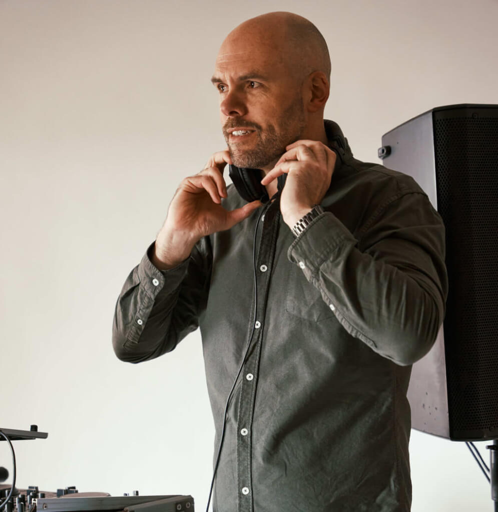 Ridler DJ holding headphones to check DJ music